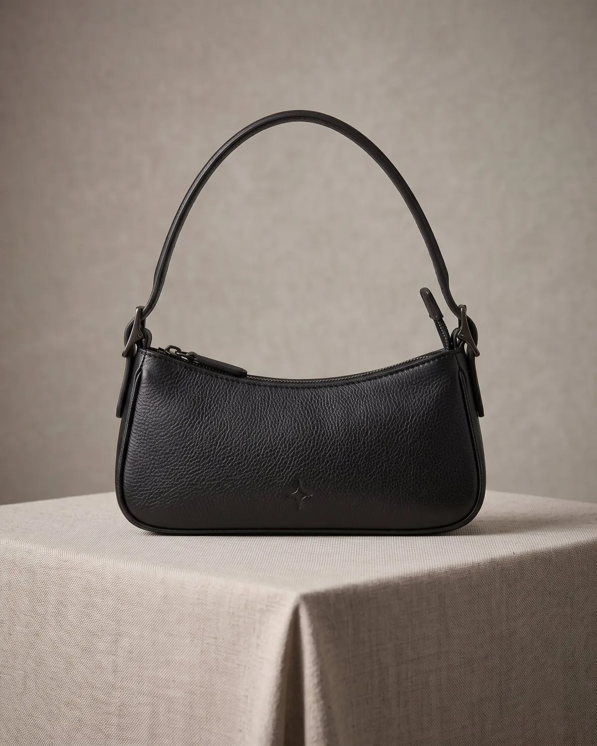 Bolso Mila — Baguette de cuero graneado con asa corta.