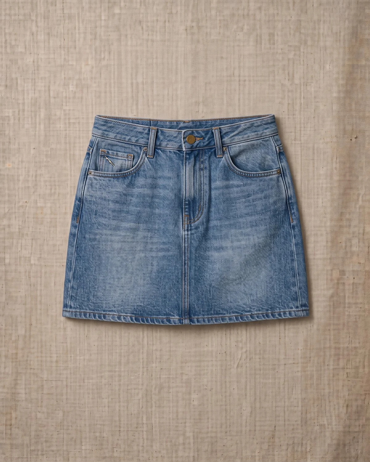 Mini Rue — Minifalda de denim con cinco bolsillos.