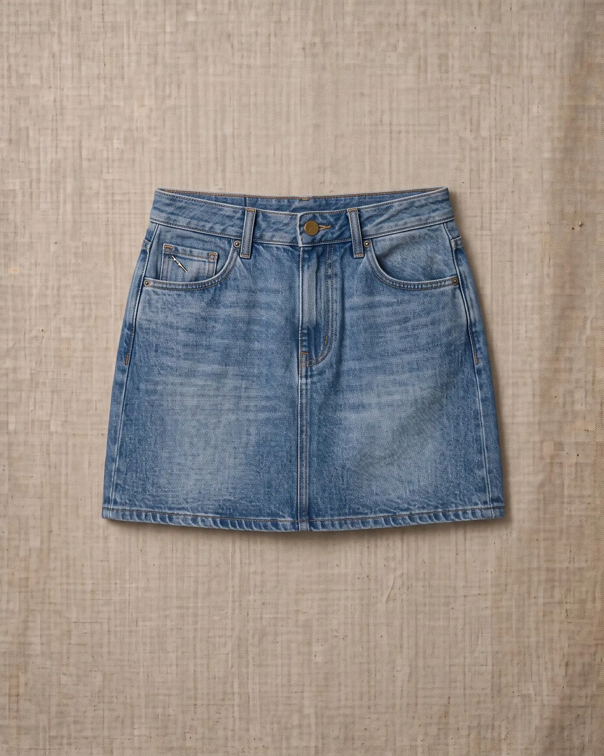 Mini Rue — Minifalda de denim con cinco bolsillos.